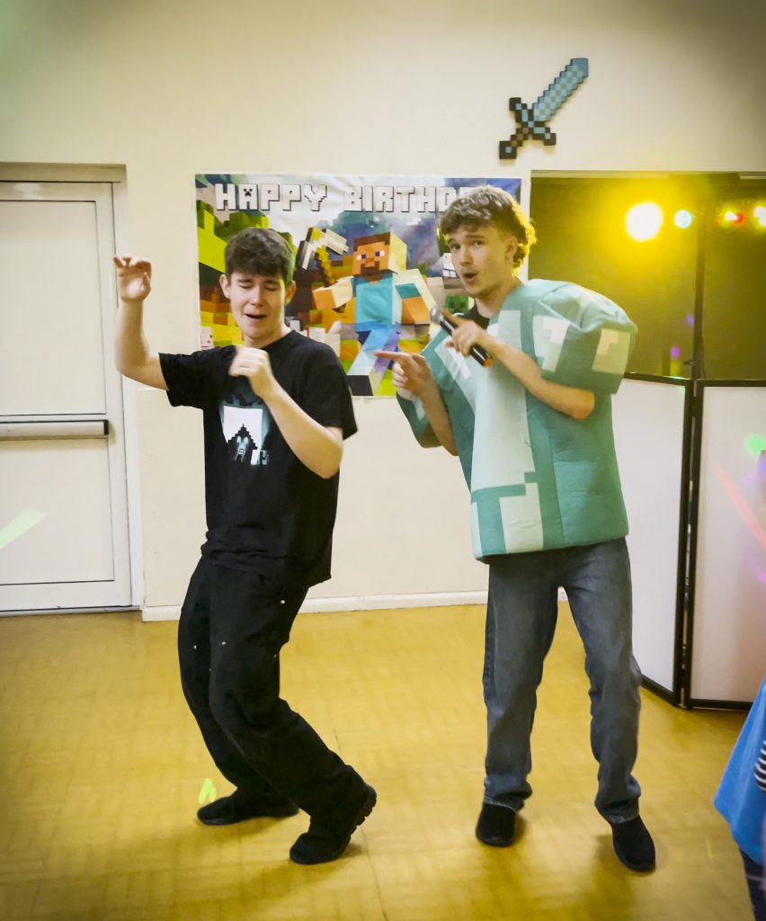 Two Minecraft party entertainers leading a dance at a birthday disco