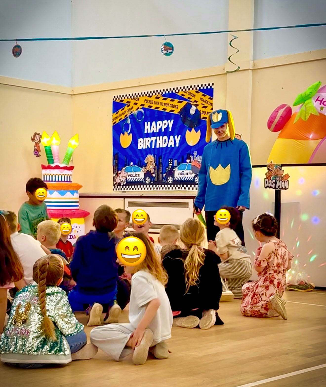 Children sitting with Dog Man entertainer at birthday party in Carnation Hall, near Fleet