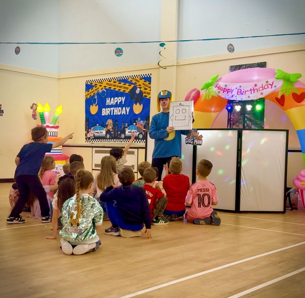 Dog Man party entertainer performing magic drawing trick at children’s birthday party in Camberley
