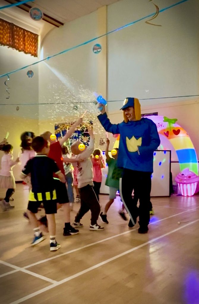 Dog Man character spraying bubbles during party games in birthday party near Guildford