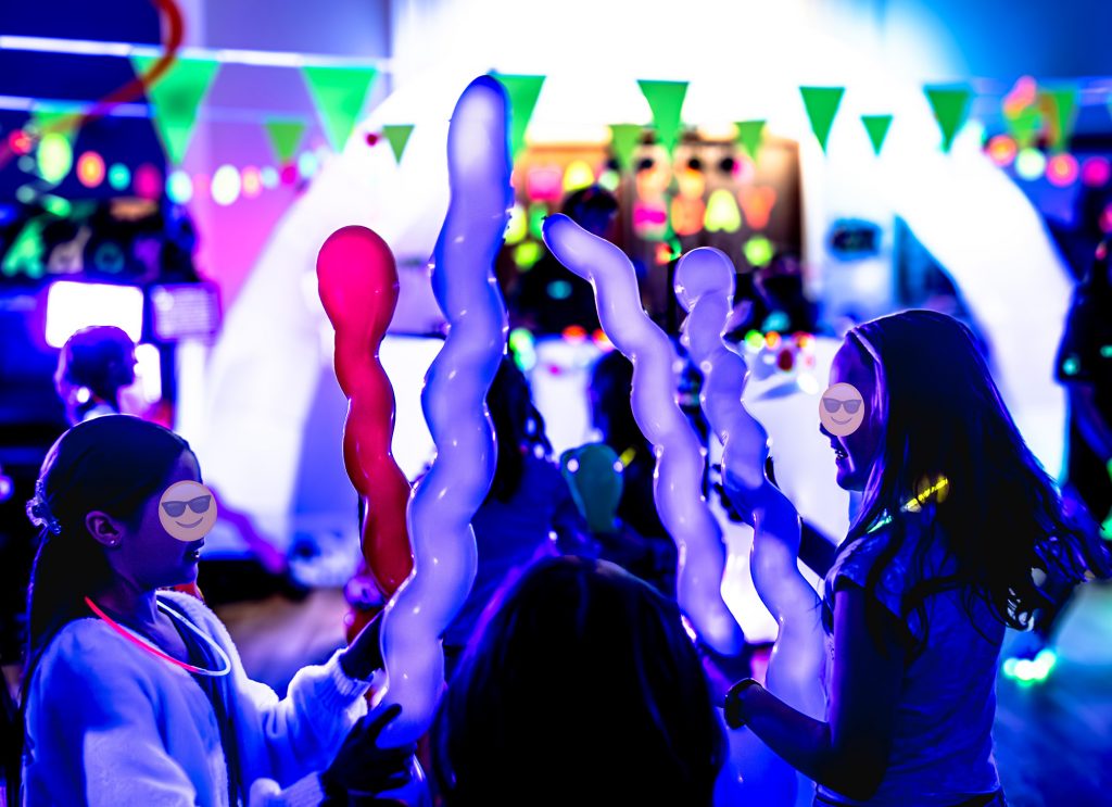 Entertainer Zak from Treasure Box Parties leading an energetic dance routine at Darcie’s Glow Disco birthday party in Bagshot. Keeping the children engaged and entertained at a vibrant UV disco party.