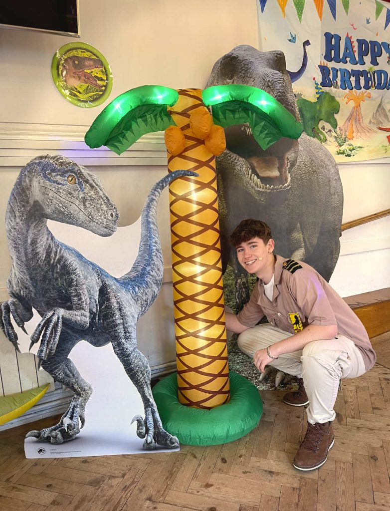 Dinosaur party entertainer from Treasure Box Parties with Jurassic decorations at a five-year-old’s birthday party near Camberley
