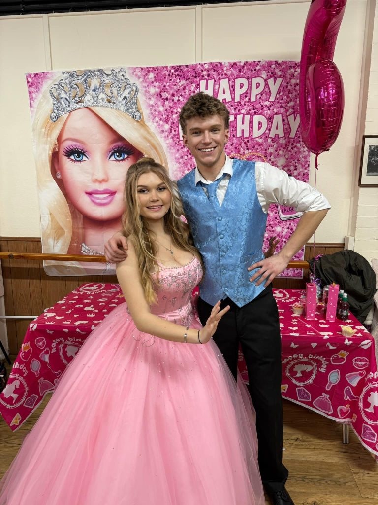 Barbie and Ken entertainers in front of a Barbie backdrop and pink party table