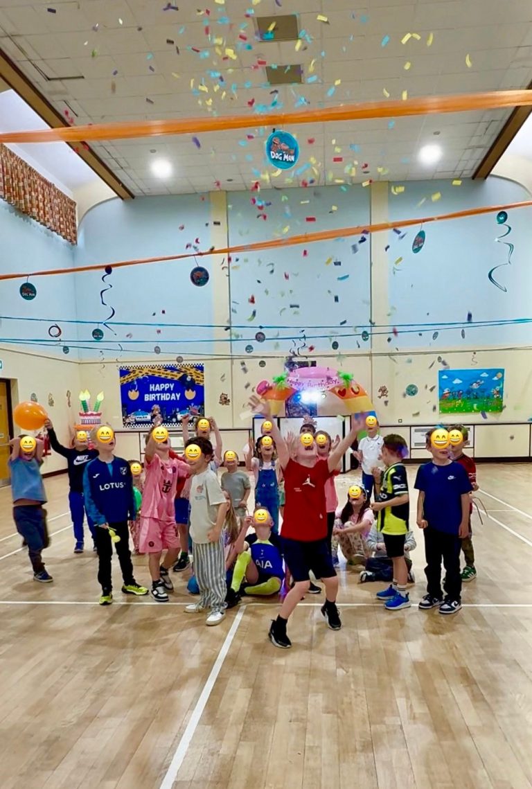 Confetti falling over children dancing in a sports hall