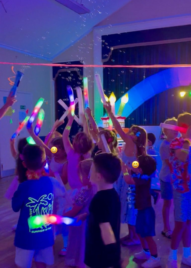 Children waving glow sticks under UV lights