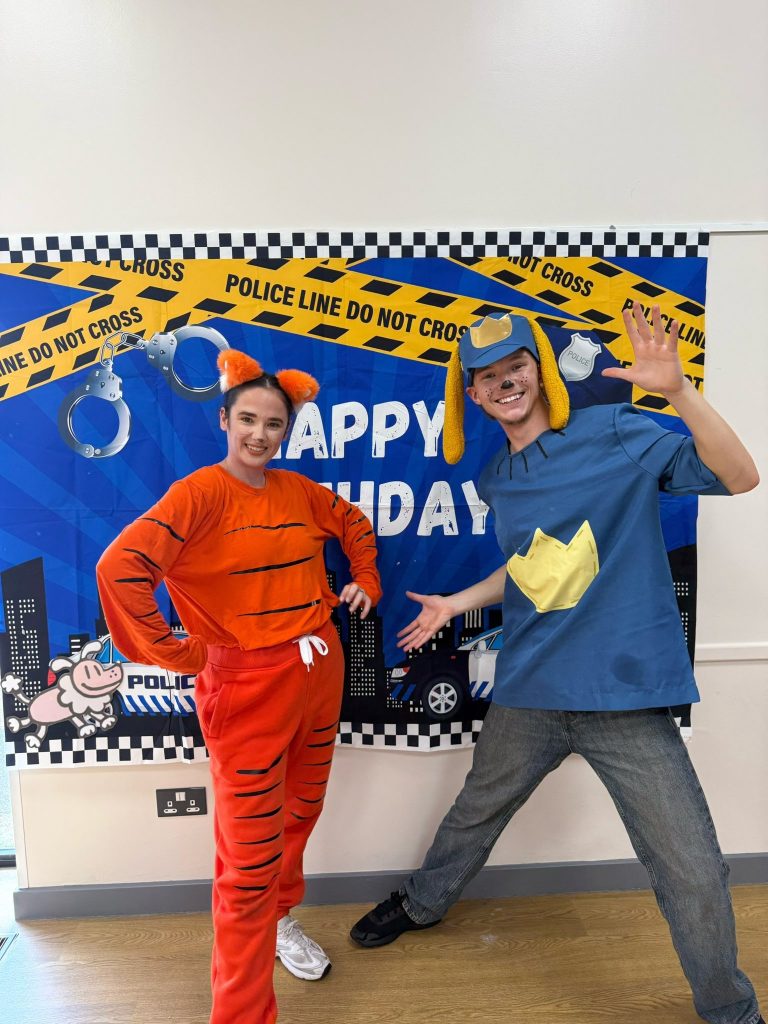Dog Man and Petey entertainers in front of a police themed birthday backdrop