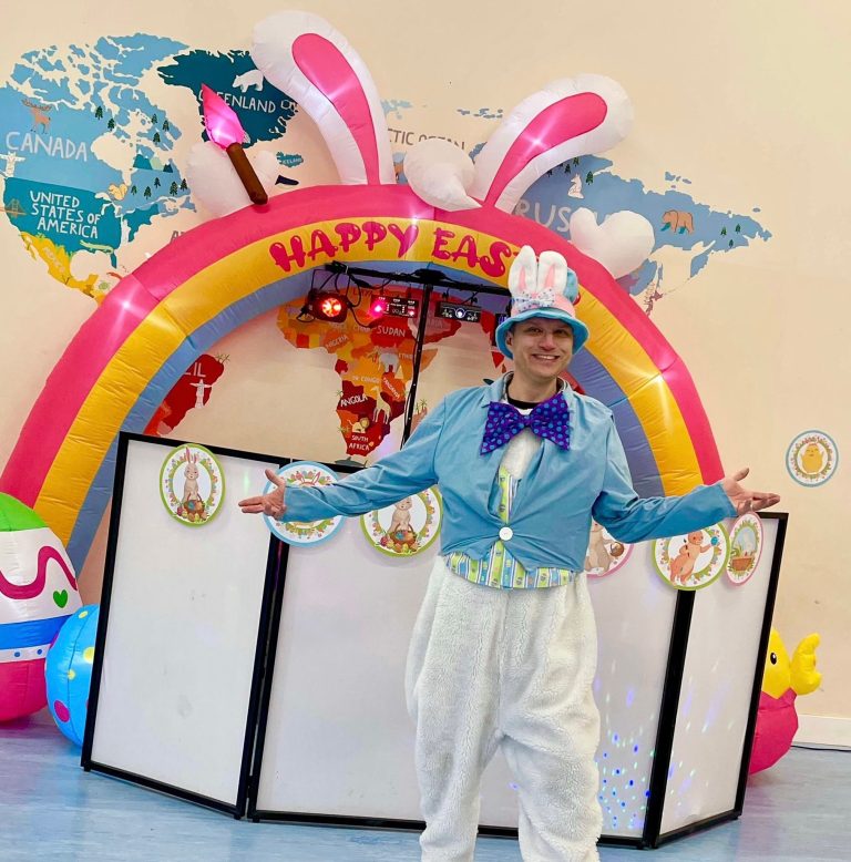 Easter bunny entertainer under a Happy Easter arch