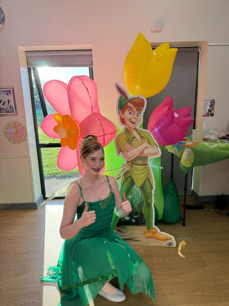 Tinker Bell entertainer with a Peter Pan cut-out and giant flower inflatables
