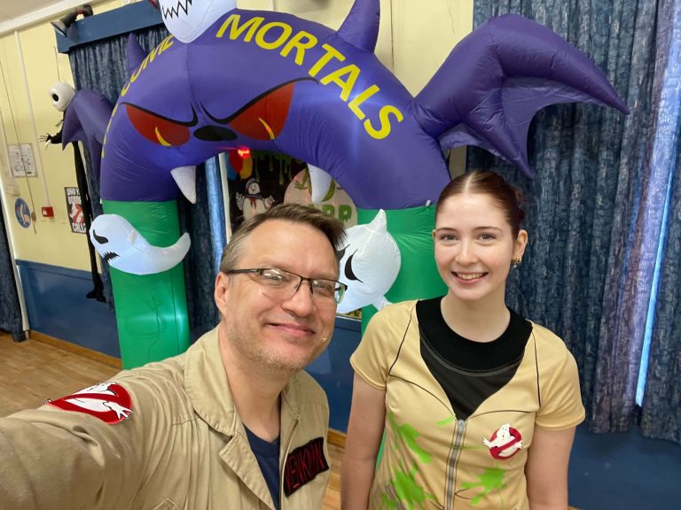 Two Ghostbuster entertainers selfie under a spooky arch