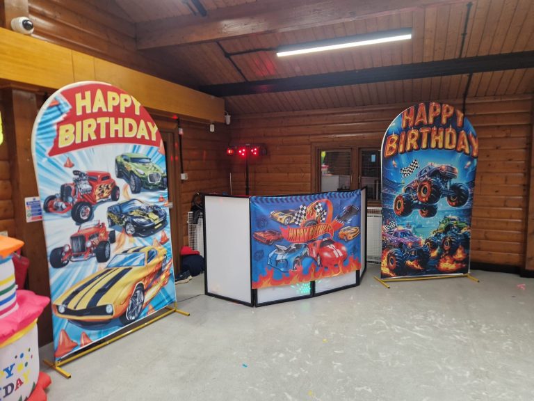 Hot Wheels and monster truck backdrops either side of the DJ booth