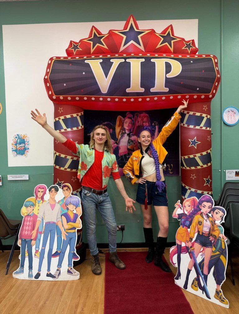 K-Pop Demon Hunters entertainers at a VIP entrance arch with character cut-outs