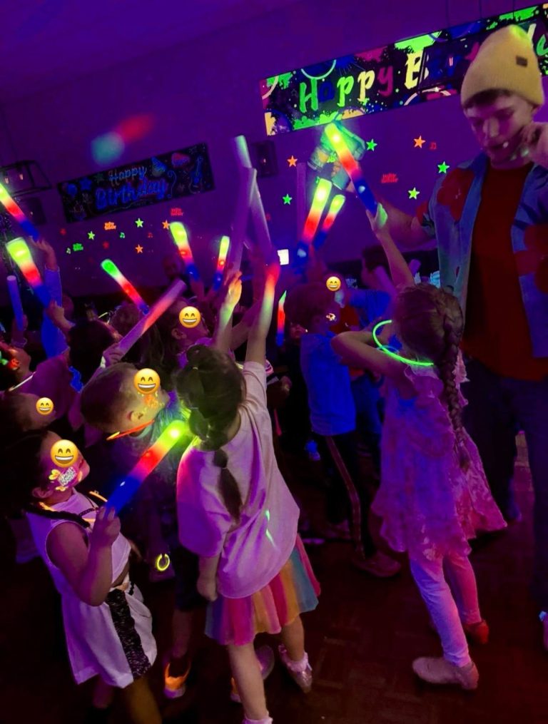 Children holding light-up sticks at a K-Pop glow party