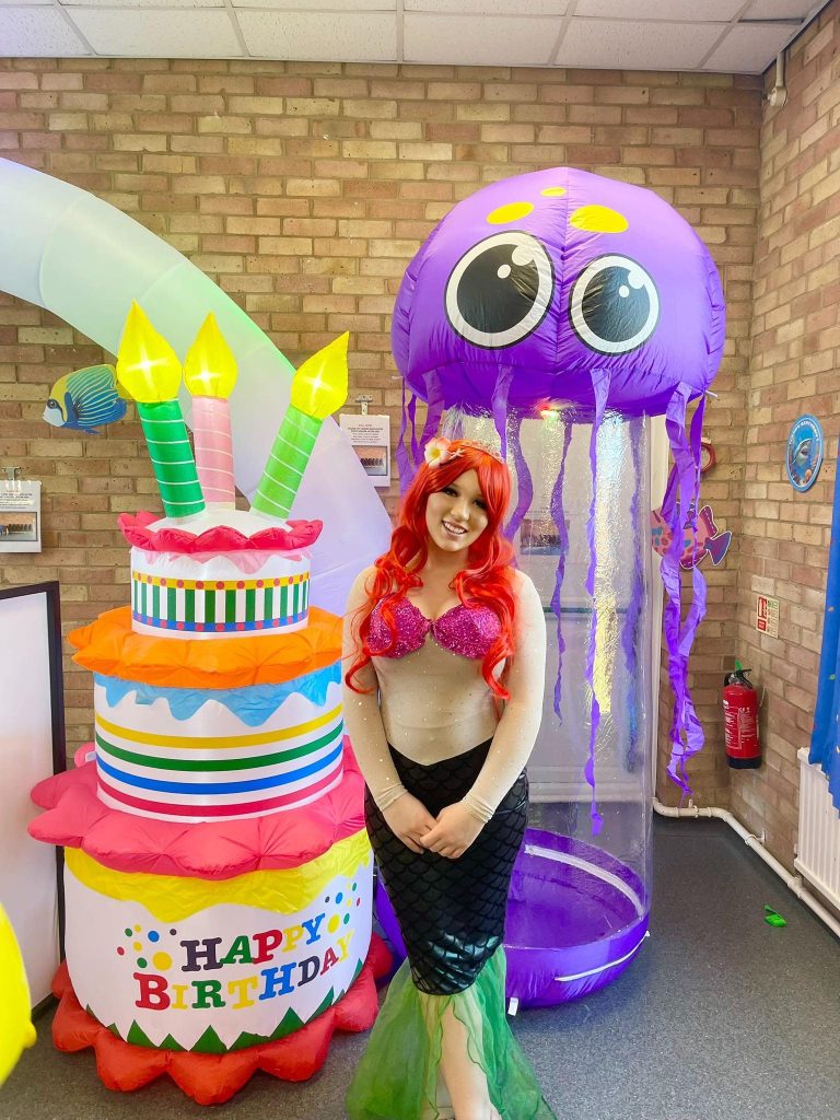 Ariel entertainer with a giant cake and jellyfish inflatable