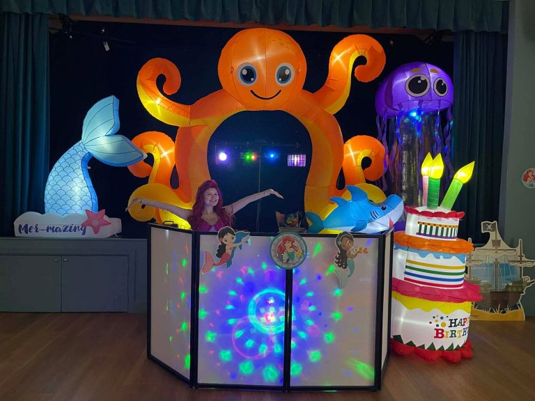 Under the sea party setup with an octopus arch, jellyfish and mermaid tail inflatables