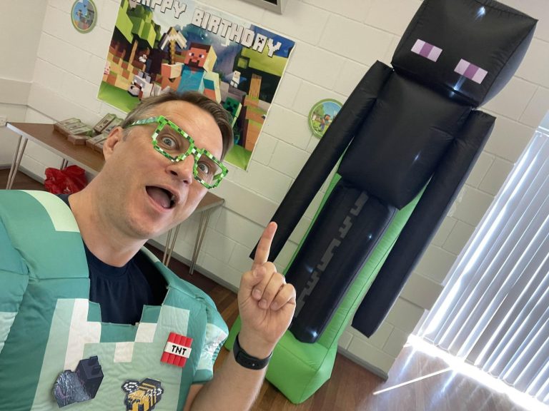 Steve entertainer in pixel costume and glasses with a giant Enderman inflatable