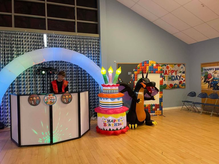 Lego Ninjago party setup with a light-up arch, Lego decorations and cake inflatable