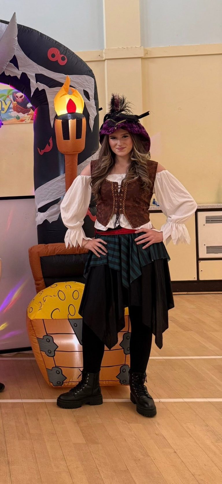 Pirate entertainer in front of a skull and crossbones pirate arch with treasure chest inflatable