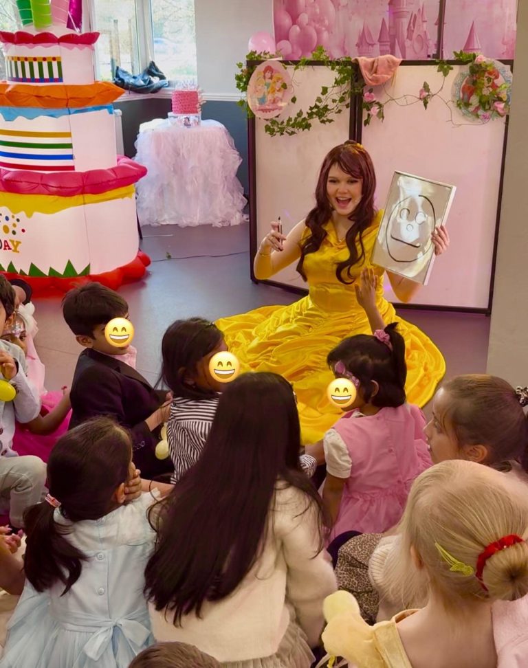 Belle sitting with children holding a magic drawing board