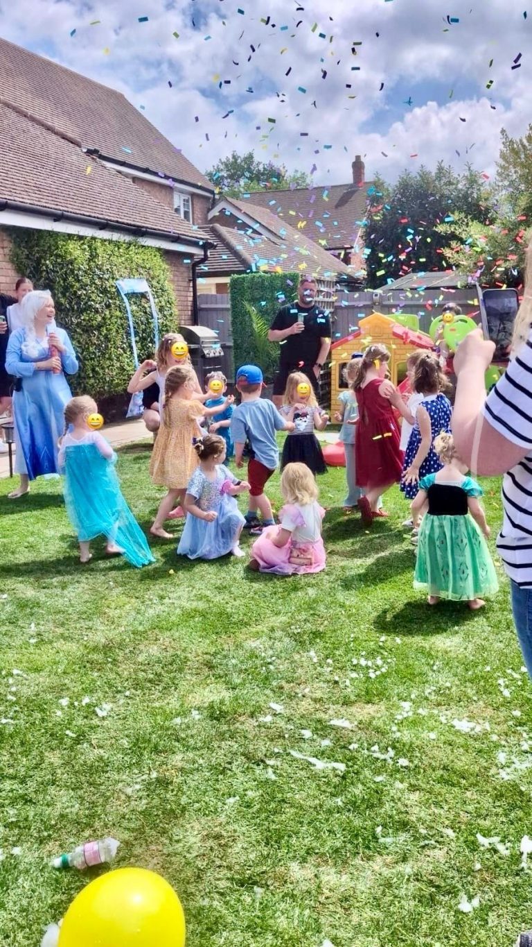 Children playing party games on the lawn at a garden party
