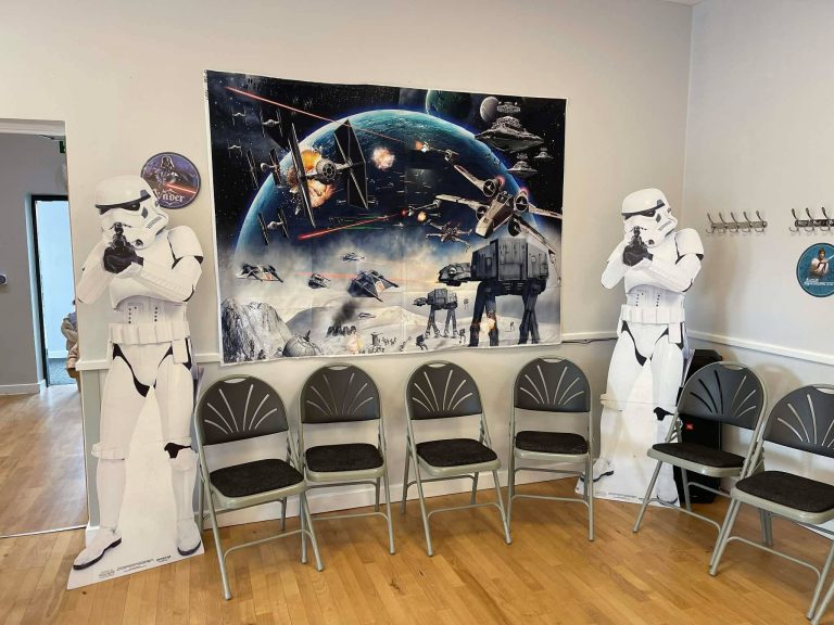 Stormtrooper cut-outs either side of a Star Wars backdrop with chairs set out