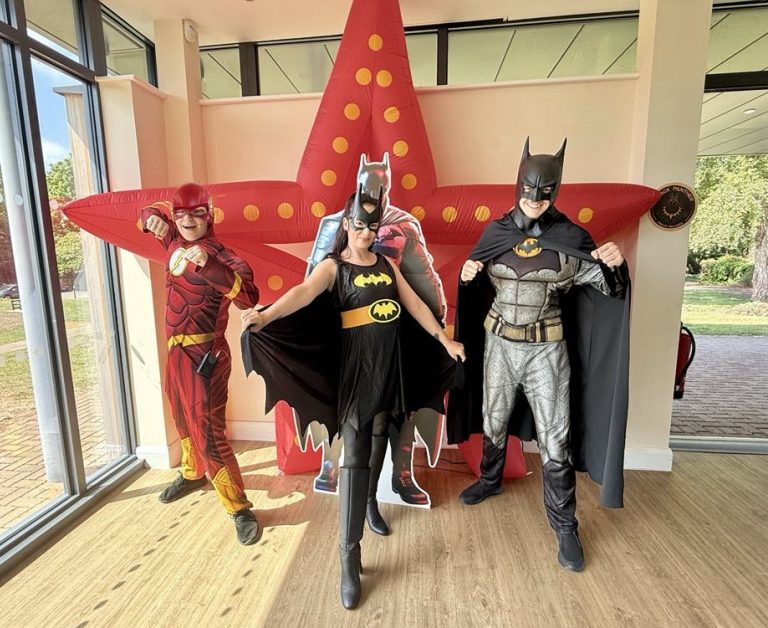 Batman, Batgirl and The Flash entertainers in front of a red star inflatable