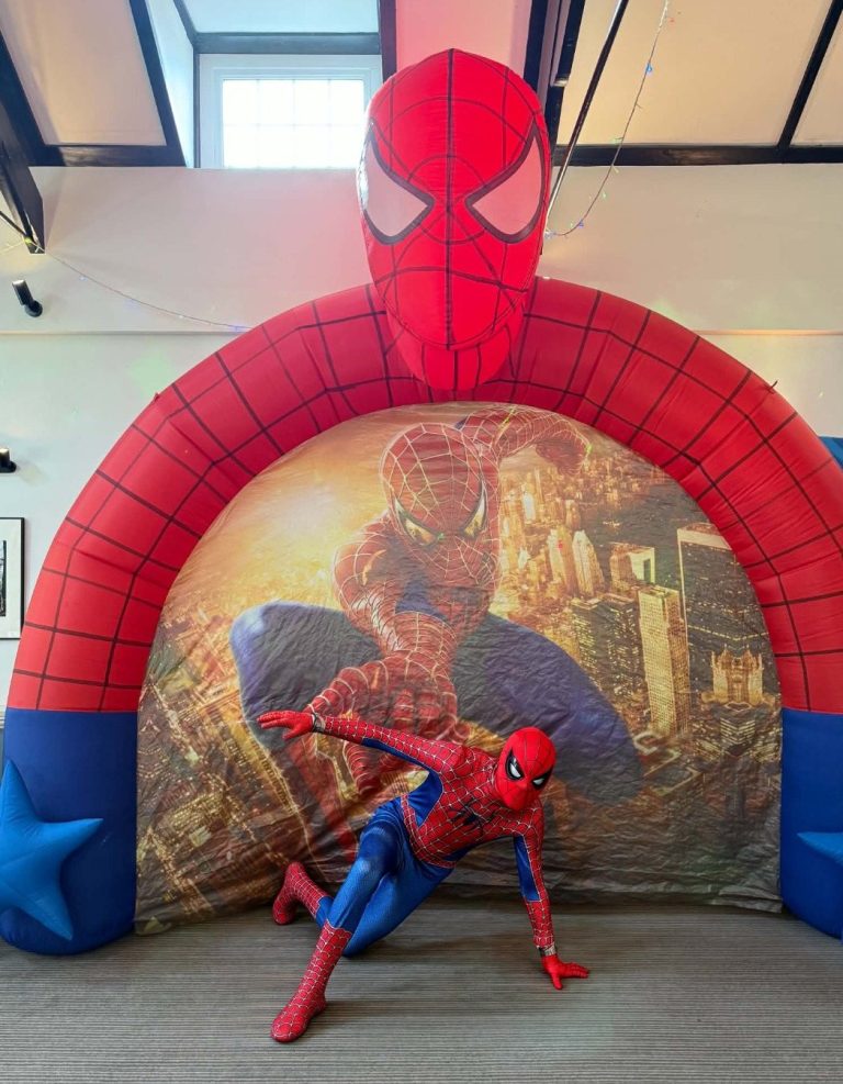Spider-Man entertainer crouching inside a giant Spider-Man arch