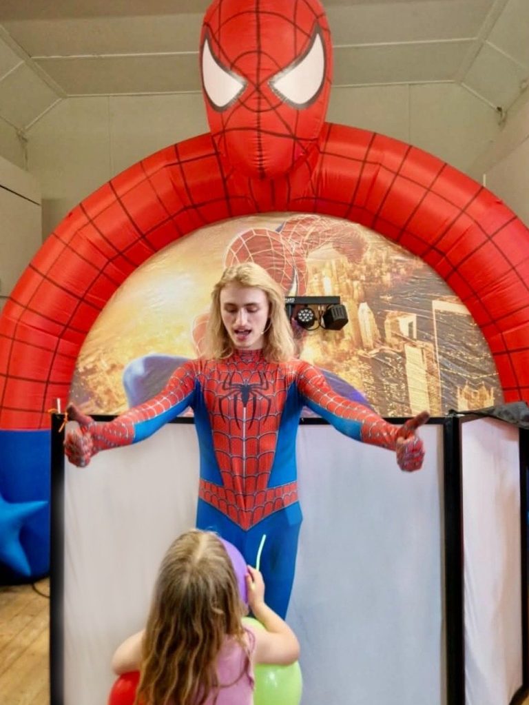 Spider-Man entertainer performing for children under the Spider-Man arch