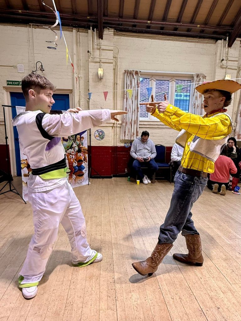 Woody and Buzz Lightyear entertainers playfully facing off during party games