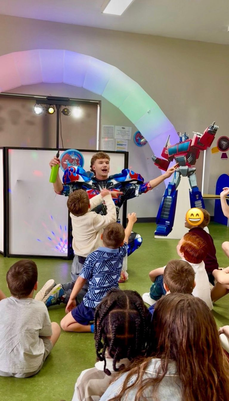 Optimus Prime entertainer leading a game beside an Optimus Prime inflatable
