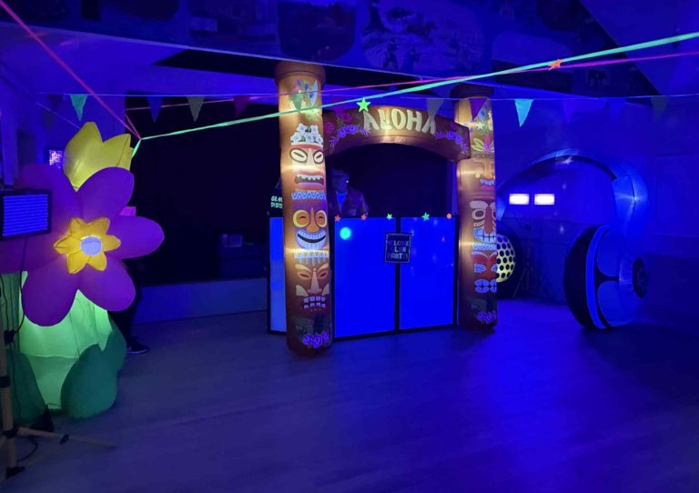 Aloha arch and glowing flower inflatables under UV lights
