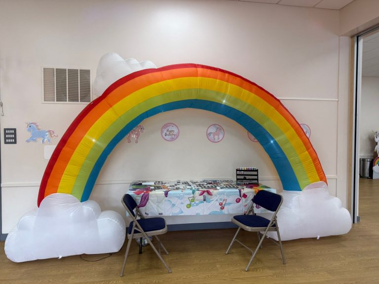 Giant rainbow and clouds inflatable over a party table