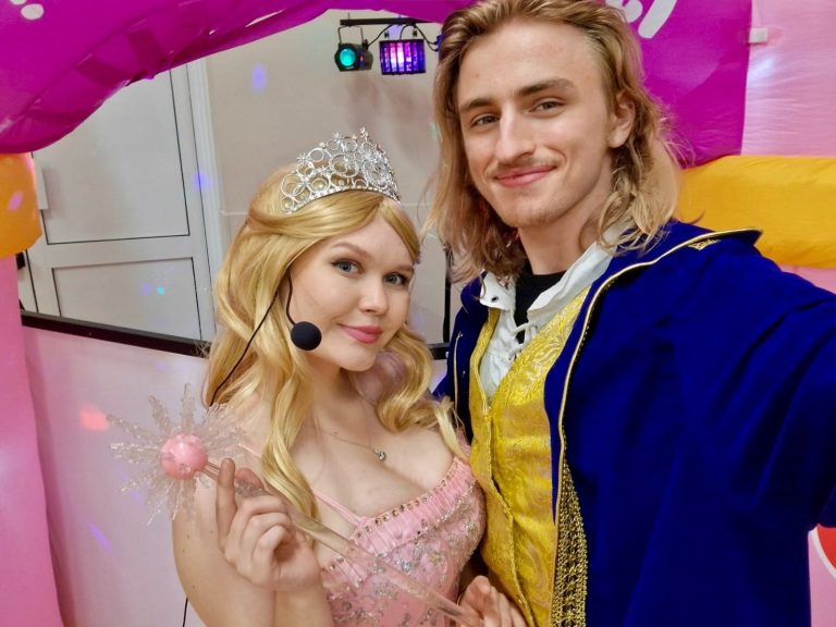 Glinda entertainer with tiara and wand in a selfie with a fellow entertainer